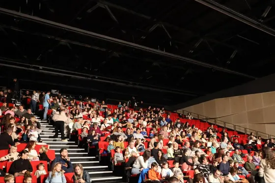Gradins rouges remplis de familles avant le spectacle
