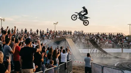 Pilote de freestyle moto en plein saut devant des tribunes pleines