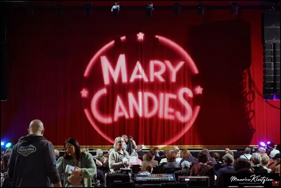 Logo Mary Candies projeté sur le rideau rouge, public qui s'installe